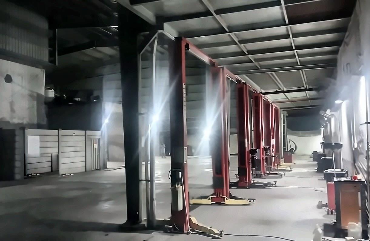 Installed red two-post vehicle lifts at the Kalma Motors workshop